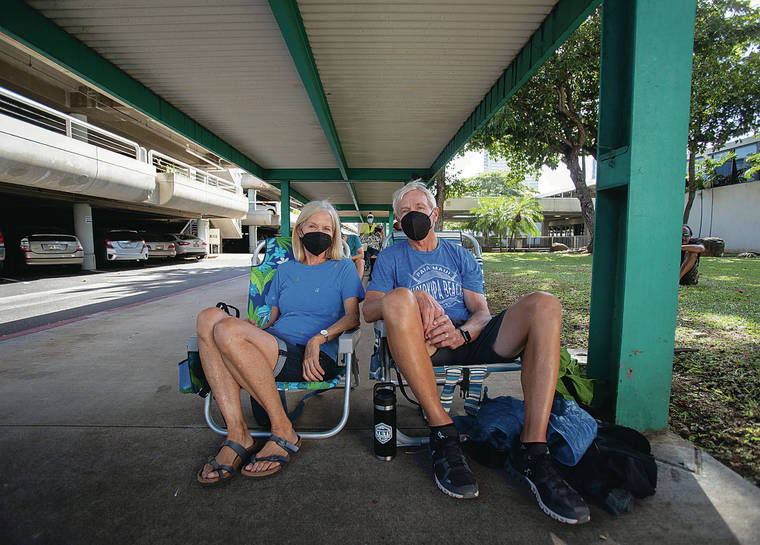 CINDY ELLEN RUSSELL / CRUSSELL@STARADVERTISER.COM
                                Carol and Terry Logan, both 70 years old, waited in the standby line in hopes of getting COVID-19 vaccinations at the Neal S. Blaisdell Center on Wednesday. The couple want to get vaccinated because the grandchildren they provide care for will be returning to school.