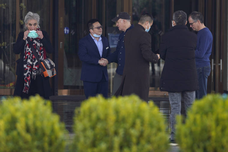 ASSOCIATED PRESS / FEB. 10
                                Marion Koopmans at left wears her mask as Peter Daszak shakes hands with a Chinese staffer outside the hotel before leaving for the airport at the end of the WHO mission in Wuhan in central China’s Hubei province.