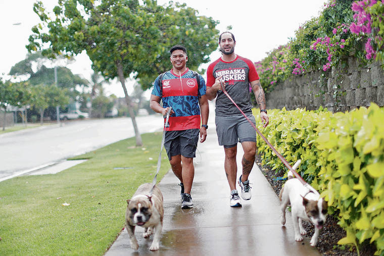 JAMM AQUINO / JAQUINO@STARADVERTISER.COM
                                COVID-19 survivor Coby Torda, left, and husband Scotty Staples walk their dogs, Sweetie and Bruno, in Ewa Beach. Torda spent 69 days at Kaiser Permanente’s Moanalua Medical Center after becoming ill with the virus in March.