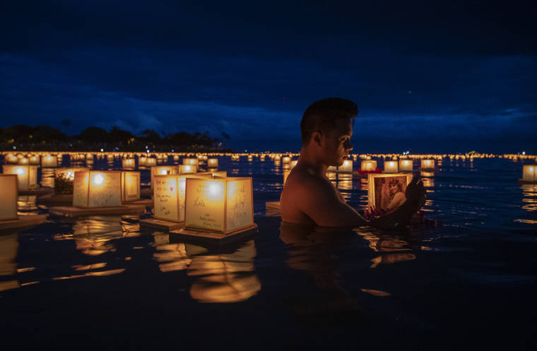 STAR-ADVERTISER / 2019
                                Edward Palma cradled a lantern dedicated to his mother, Estarlina Penalba, at the Shinnyo Lantern Floating Hawaii 2019 Ceremony held at Ala Moana Regional Park on Memorial Day. Approximately 50,000 people gathered to set 7,000 lanterns afloat in remembrance of loved ones.