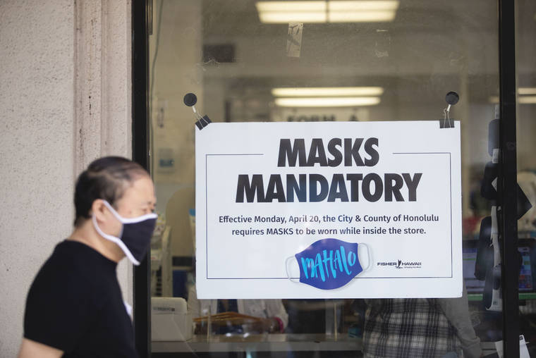 CINDY ELLEN RUSSELL / CRUSSELL@STARADVERTISER.COM
                                A pedestrian wears a mask while walking past a mask mandate sign on the window of Fisher Hawaii in downtown Honolulu on Friday.