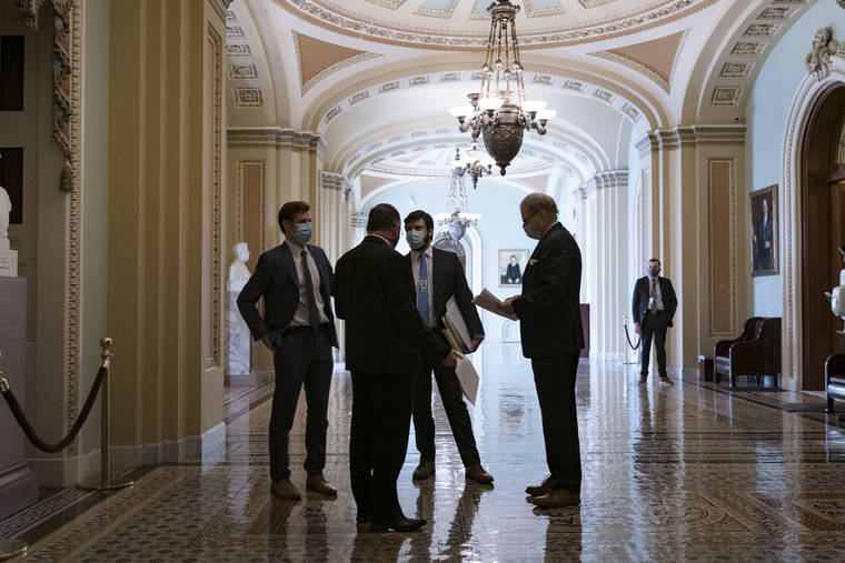 ASSOCIATED PRESS
                                Congressional staffers waited in the ornate corridor outside the Senate chamber during a delay in work on the Democrats’ $1.9 trillion COVID-19 relief bill, at the Capitol in Washington, today.