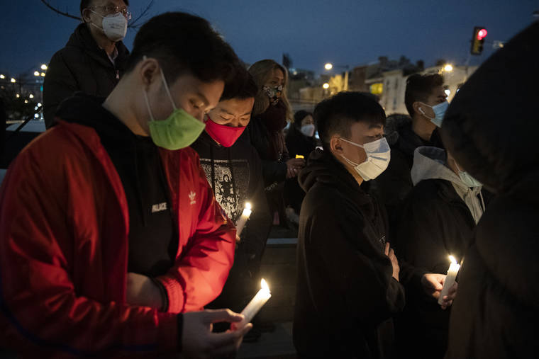 Community members gather for a vigil to mourn and confront the rising violence against Asian Americans at the 10th Street Plaza, Wednesday, March 17, 2021, in Philadelphia. The vigil was held following a mass shooting in Atlanta that killed eight people, six of them women of Asian decent. (Joe Lamberti/Camden Courier-Post via AP)