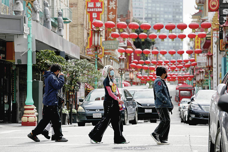 TRIBUNE NEWS SERVICE
                                Masked people walk in San Francisco’s Chinatown along Grant Avenue. The San Francisco Department of Public Health recently updated a COVID-19 health order to allow many businesses to reopen with fewer restrictions.