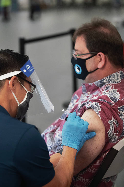 CINDY ELLEN RUSSELL / CRUSSELL@STARADVERTISER.COM
                                Hawaii officials plan to vaccinate those 70 and older around March 15 and the 65-plus age group a couple of weeks later. Above, health care worker Jeffrey Lum administered the Pfizer vaccine to Sam Cropsey at Pier 2 on Friday.