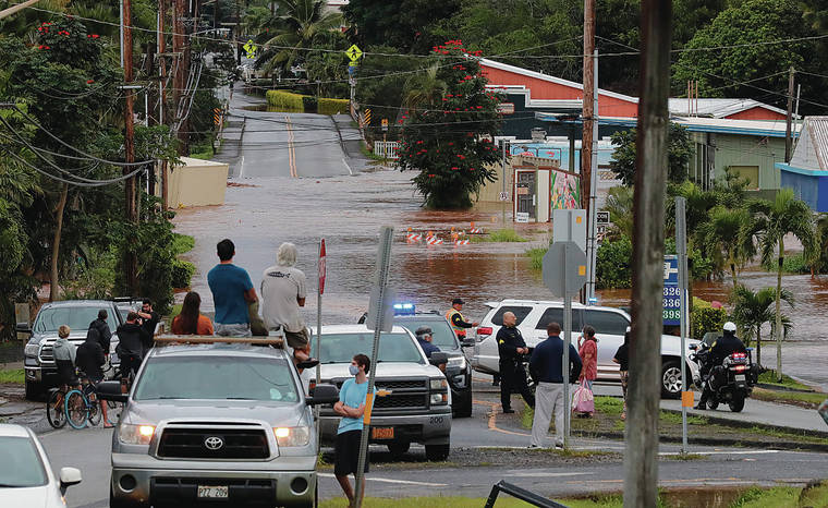 JAMM AQUINO / JAQUINO@STARADVERTISER.COM
                                Bystanders in Haleiwa observed the flooding on Haleiwa Road on March 9.