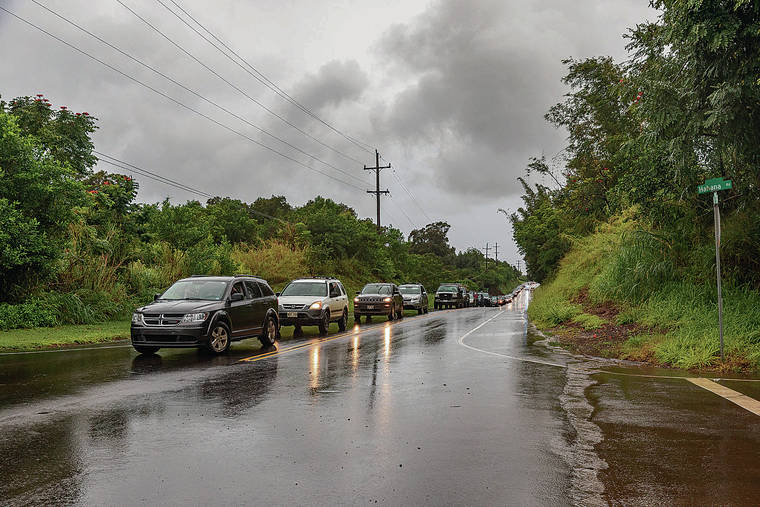 BRYAN BERKOWITZ / SPECIAL TO THE STAR-ADVERTISER
                                A rain gauge in the Haiku area recorded 13.81 inches of rain between 7 a.m. and 3 p.m. Monday. Above, about 100 cars waited on Peahi Road as police set up a roadblock.