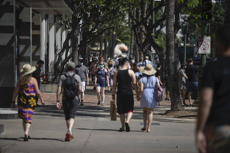 CINDY ELLEN RUSSELL / APRIL 5
                                Masked and unmasked pedestrians stroll along Kalakaua Avenue in Waikiki on Monday.