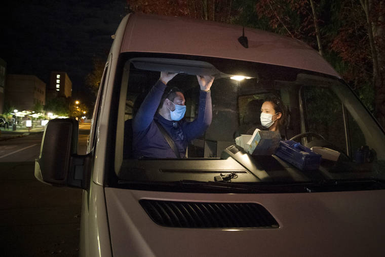 WILLIAM HOLDERFIELD VIA ASSOCIATED PRESS
                                Crisis Workers, Emergency Medical Technicians (EMTs), Henry Cakebread and Ashley Barnhill-Hubbard with CAHOOTS, a mental health crisis intervention program, discussed their last encounter, in Oct. 2020, during their night shift in Eugene, Ore.