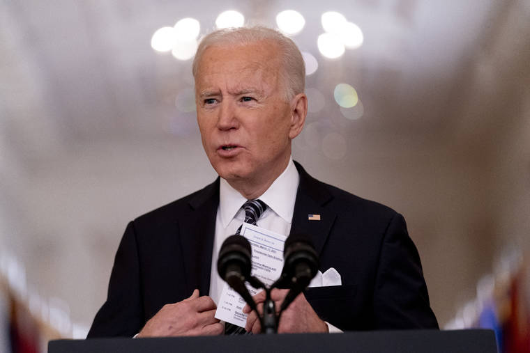 ASSOCIATED PRESS
                                President Joe Biden holds up a card with his daily schedule and the daily deaths from COVID-19 as he speaks about the COVID-19 pandemic during a prime-time address from the East Room of the White House in Washington on March 11.