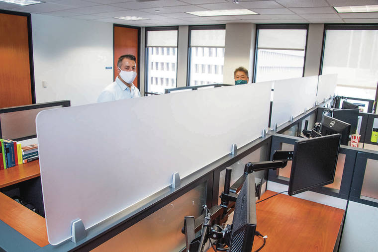 CRAIG T. KOJIMA / CKOJIMA@STARADVERTISER.COM
                                The office layout at Atlas Insurance had to be reconfigured to create more space for physical distancing. Joey Barroso, risk consultant manager, and Chason Ishii, president, stand behind Plexiglas barriers installed between desks.
