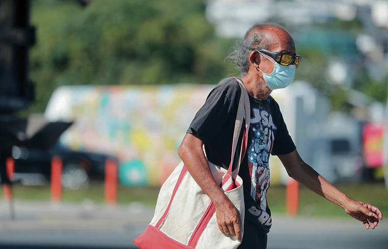 JAMM AQUINO / JAQUINO@STARADVERTISER.COM
                                Hawaii recorded 61 new coronavirus infections Tuesday. A pedestrian wearing a mask walked across Waialae Avenue.