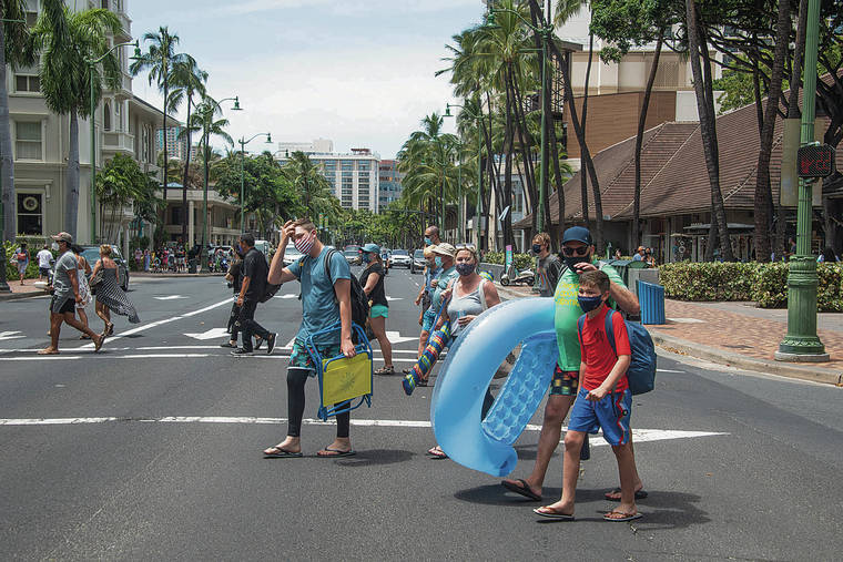 CRAIG T. KOJIMA / CKOJIMA@STARADVERTISER.COM
                                Pedestrians cross Kalakaua Avenue earlier this month in Waikiki, where the number of visitors appears to be growing.