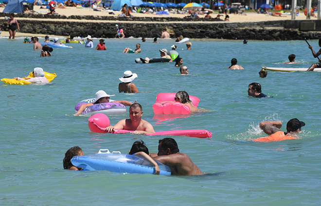 CRAIG T. KOJIMA / CKOJIMA@STARADVERTISER.COM
                                Duke Kahanamoku Beach at the Hilton Hawaiian Village Resort was busy, April 21, with a crowd including many visitors. Visitor arrivals to Hawaii in March increased for the first time in a year, but just a smidgen.