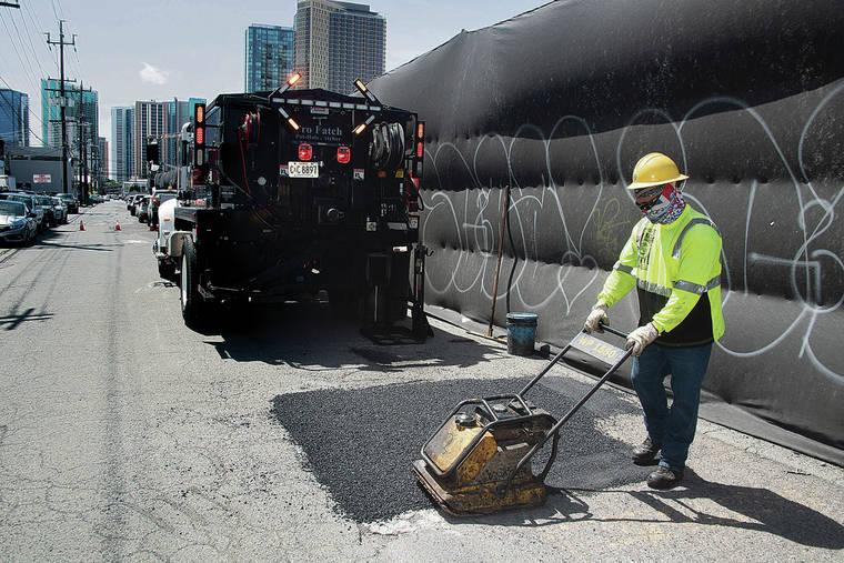 CRAIG T. KOJIMA / CKOJIMA@STARADVERTISER.COM
                                A city crew has been scheduled to start patching potholes on several Kakaako streets that were returned to public ownership in February by a state judge. Shy Kamoe-Kaleikini, above, packed down asphalt Tuesday before moving on to the next pothole in Kakaako.