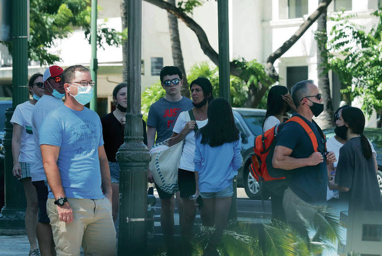 JAMM AQUINO / JAQUINO@STARADVERTISER.COM
                                Gov. Ige is worried about people dropping their guard, especially if they know that they’ve been vaccinated and tend to think that it’s back to business as usual. Above, pedestrians were both masked and unmasked Monday in Waikiki.