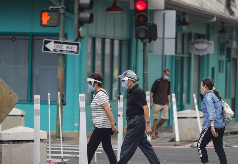 JAMM AQUINO / JAQUINO@STARADVERTISER.COM
                                Pedestrians wearing facial coverings walk on Maunakea Street today in Honolulu.