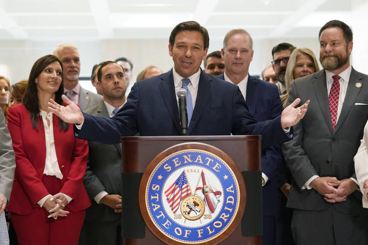 ASSOCIATED PRESS
                                Surrounded by lawmakers, Florida Gov.Ron DeSantis spoke at the end of a legislative session, Friday, at the Capitol in Tallahassee, Fla.