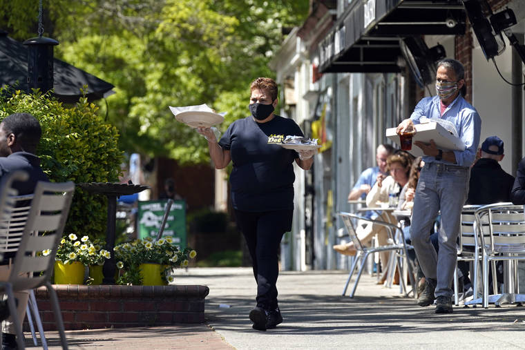 ASSOCIATED PRESS
                                A member of the wait staff took food to outdoor diners at the Mediterranean Deli restaurant in Chapel Hill, N.C., April 16. Thousands of restaurants and bars decimated by COVID-19 have a better chance at survival as the government begins handing out $28.6 billion in grants — money to help these businesses stay afloat while they wait for customers to return.
