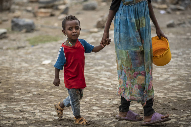 ASSOCIATED PRESS
                                A displaced Tigrayan boy walks with a relative to receive food at the Hadnet General Secondary School which has become a makeshift home to thousands displaced by the conflict, in Mekele, in the Tigray region of northern Ethiopia, today.