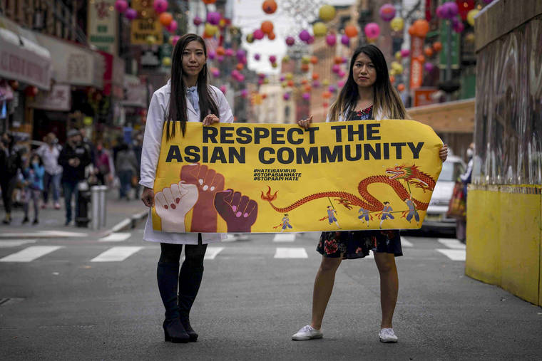 ASSOCIATED PRESS
                                Dr. Michelle Lee, left, a radiology resident, and Ida Chen, right, a physician assistant student, unfolded a banner Lee created to display at rallies protesting anti-Asian hate, April 24, in New York’s Chinatown. Lee, who is Korean-born, and Chen, who is American-born Chinese, join medical professionals of Asian and Pacific Island descent who feel the anguish of being racially targeted because of the virus while toiling to keep people from dying of it.