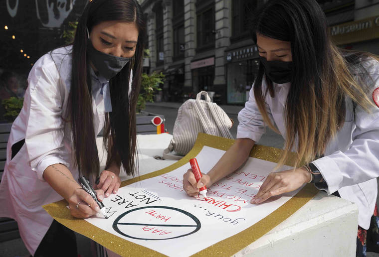 ASSOCIATED PRESS
                                Dr. Michelle Lee, left, a radiology resident, and Ida Chen, right, a physician assistant student, prepared posters they carry at rallies protesting anti-Asian hate, April 24, in New York’s Chinatown. Lee, who is Korean-born, and Chen, who is American-born Chinese, joined medical professionals of Asian and Pacific Island descent who feel the anguish of being racially targeted because of the virus while toiling to keep people from dying of it.