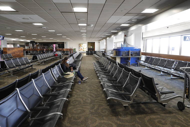 JAMM AQUINO / JAQUINO@STARADVERTISER.COM
                                A Kauai resident waited in a nearly empty gate area for her flight to Lihue, in Oct. 2020, at Daniel K. Inouye International Airport. In just three weeks the number of confirmed COVID-19 cases on Kauai since the pandemic began had jumped from 199 to 289 as of Monday.