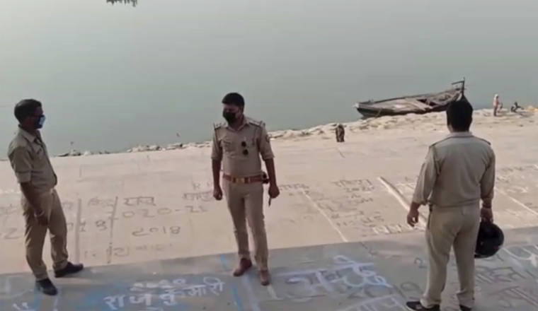 KK PRODUCTIONS VIA ASSOCIATED PRESS
                                This frame grab from video shows police officials standing guard at the banks of the river where several bodies were found lying in Ghazipur district in Uttar Pradesh state India, today.