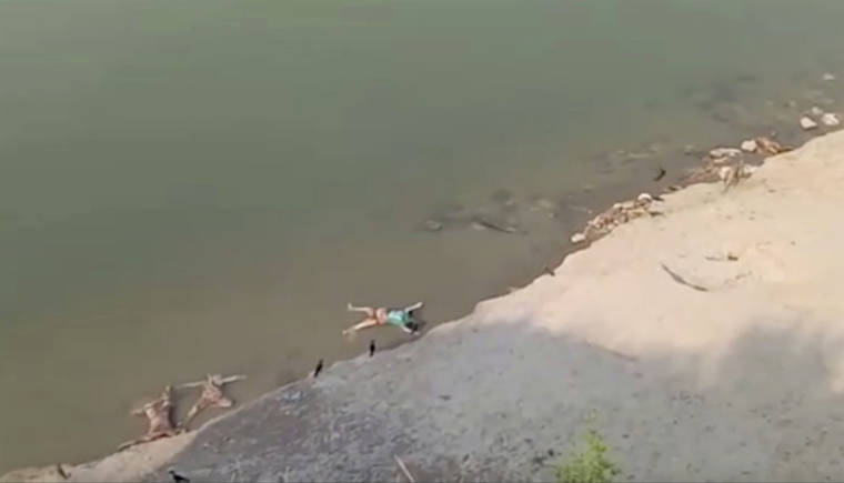KK PRODUCTIONS VIA ASSOCIATED PRESS
                                This frame grab from video shows bodies lying along the river in Ghazipur district in Uttar Pradesh state India, today. Scores of dead bodies have been found floating down the Ganges River in eastern India amid a ferocious surge in coronavirus infections in the country, but authorities said today they haven’t been able to determine the cause of death. Health officials working through the night Monday retrieved 71 bodies, officials in Bihar state said.