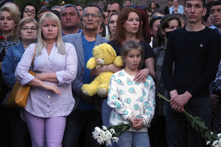 ASSOCIATED PRESS
                                People stood near a school with toys and flowers after a shooting in Kazan, Russia, Tuesday. A gunman launched an attack on a school in the Russian city of Kazan that left at least nine people dead Tuesday — including seven youngsters — and sent students hiding under their desks or running out of the building.