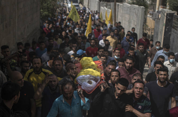 ASSOCIATED PRESS
                                Palestinian mourners carry the body of 11-year-old Hussain Hamad, who was killed by an explosion during the ongoing conflict between Israel and Hamas, during his funeral in Beit Hanoun, northern Gaza Strip today.
