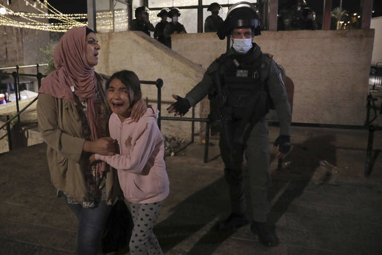 ASSOCIATED PRESS
                                An Israeli police officer gestures to a Palestinian woman and her daughter, frightened by clashes outside of the Damascus Gate to the Old City of Jerusalem today. A confrontation between Israel and Hamas sparked by weeks of tensions in contested Jerusalem escalated today as Israel unleashed new airstrikes on Gaza while militants barraged Israel with hundreds of rockets.