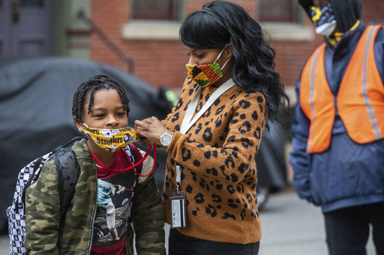 Andrew Rush/Pittsburgh Post-Gazette via ASSOCIATED PRESS
                                Jenea Edwards, of the North Side, helped her son Elijah, 9, in the third grade, with his mask before heading into Manchester Academic Charter School, March 29, on the first day of in-person learning via a hybrid schedule, in Pittsburgh. Dozens of school districts around the country have eliminated requirements for students to wear masks, and many more are likely to ditch mask requirements before the next academic year.