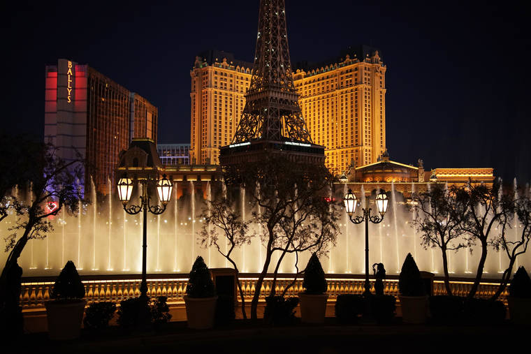 ASSOCIATED PRESS
                                A woman watched the fountains at the Bellagio hotel-casino, in Nov. 2020, along the Las Vegas Strip in Las Vegas. Gambling giants MGM Resorts International and Caesars Entertainment said Wednesday were opening their Las Vegas Strip gambling floors at 100% capacity with no person-to-person distancing requirement, after state regulatory approval.
