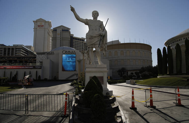 ASSOCIATED PRESS
                                Gates blocked an entrance to Caesars Palace hotel and casino, in May 2020, along the Las Vegas Strip in Las Vegas. Gambling giants MGM Resorts International and Caesars Entertainment said, Wednesday, they were opening their Las Vegas Strip gambling floors at 100% capacity with no person-to-person distancing requirement, after state regulatory approval.