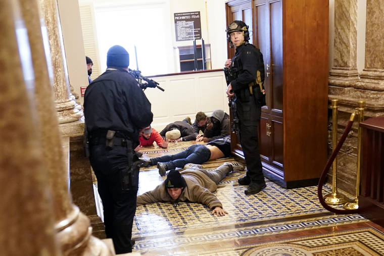 ASSOCIATED PRESS
                                U.S. Capitol Police held rioters at gunpoint, Jan. 6, near the House Chamber inside the U.S. Capitol in Washington.
