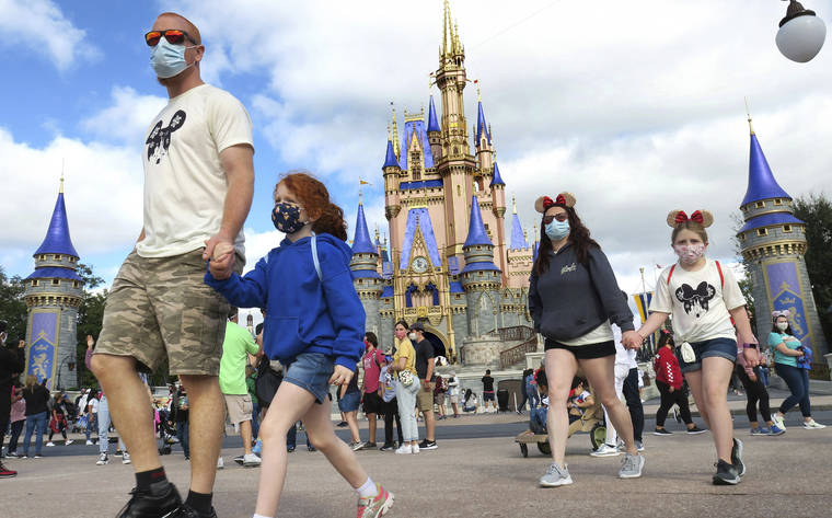 ASSOCIATED PRESS / DEC. 21
                                A family walks past Cinderella Castle in the Magic Kingdom, at Walt Disney World in Lake Buena Vista, Fla., in December. Florida’s major theme parks are adjusting their face mask policies after the federal government loosened its recommendations as more people get vaccinated for the coronavirus.