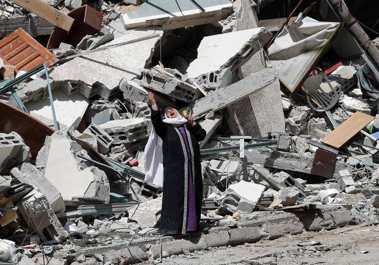 ASSOCIATED PRESS
                                A woman reacts while standing near the rubble of a building that was destroyed by an Israeli airstrike on Saturday that housed the Associated Press, broadcaster Al-Jazeera and other media outlets, in Gaza City, today.