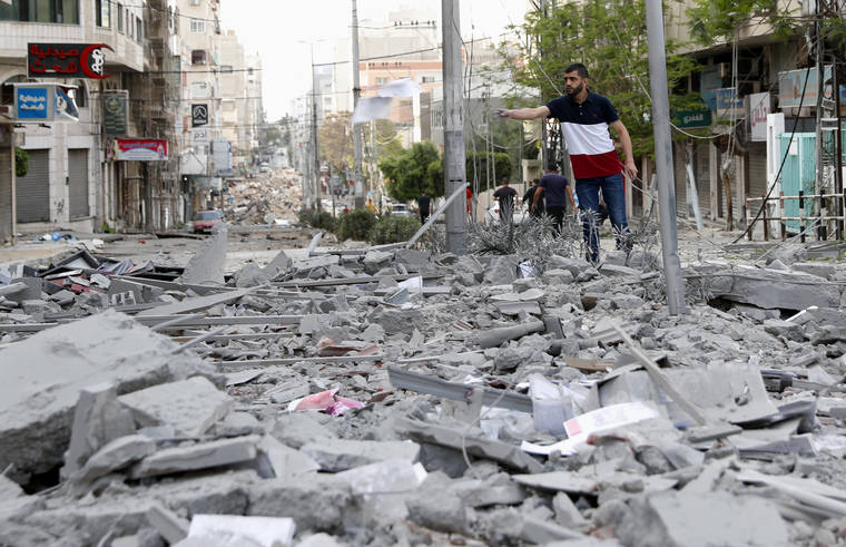 ASSOCIATED PRESS
                                A man inspects the rubble of destroyed commercial building and Gaza health care clinic following an Israeli airstrike on the upper floors of a commercial building near the Health Ministry in Gaza City today.