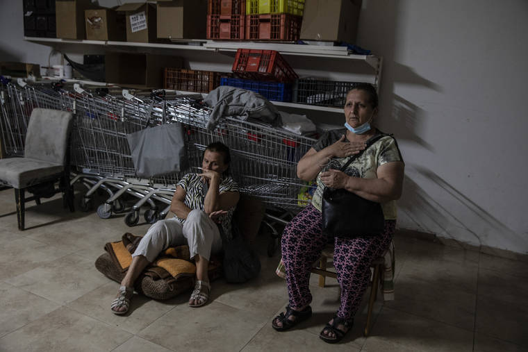 ASSOCIATED PRESS
                                Israeli Kassadra Bodari, left, and Lilian Feciouru took shelter in Ashdod, Israel during sirens warning of incoming rockets fired from Gaza Strip, today.