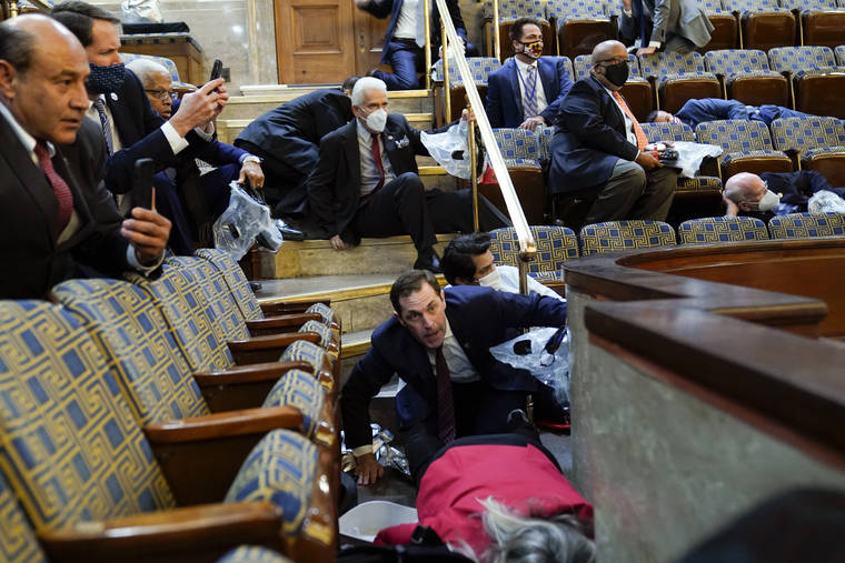ASSOCIATED PRESS
                                People sheltered in the House chamber, Jan. 6, as rioters tried to break into the House Chamber at the U.S. Capitol in Washington.