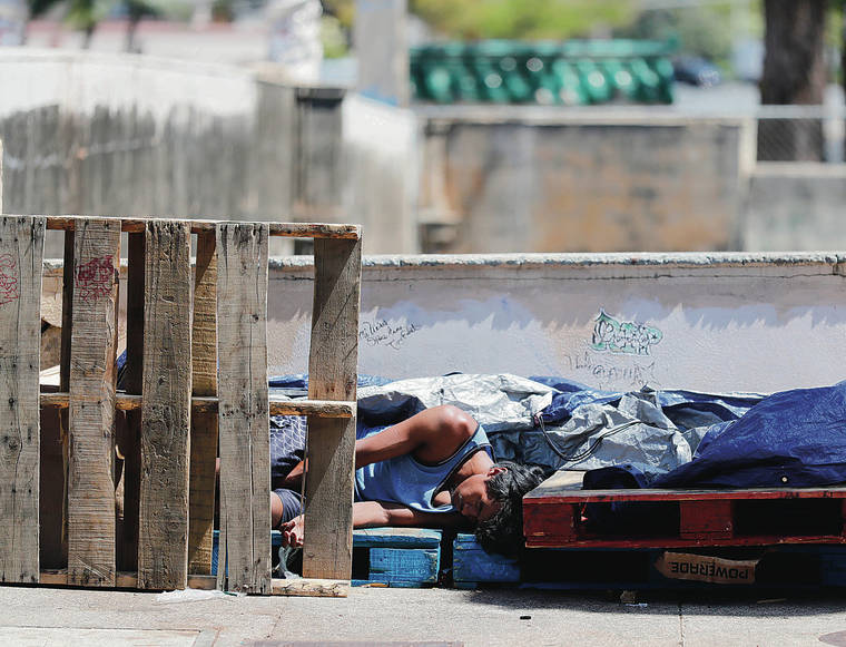 JAMM AQUINO / JAQUINO@STARADVERTISER.COM
                                A homeless man slept on the sidewalk on River Street.