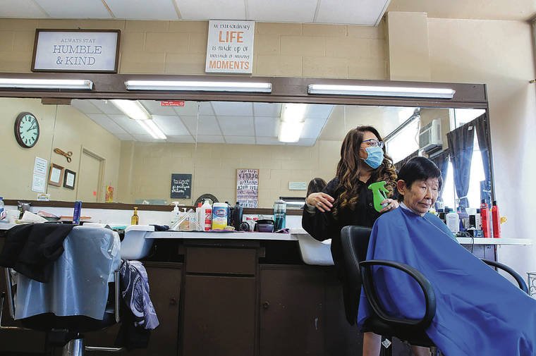 JAMM AQUINO / JAQUINO@STARADVERTISER.COM
                                Elizabeth Temple, owner of Riverside Barbershop in Chinatown, kept an eye on the street Monday as she cut the hair of Kaneohe resident Keiki Tsuchida.