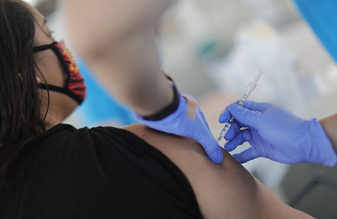 JAMM AQUINO /JAQUINO@STARADVERTISER.COM
                                A Pfizer-BioNTech COVID-19 vaccine is administered during a Kaiser Permanente vaccination clinic at Papakolea Community Center on Tuesday in Honolulu. Nearly 1.4 million vaccination doses have already been administered so far in Hawaii.