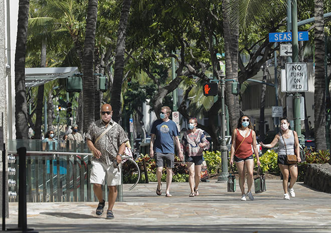 JAMM AQUINO / MAYIS 4 Yürüyüşçü Maskeli Waikiki'de Kalakaua Caddesi'nde yürüyor.  Vali David Ige, Perşembe günü, Hastalık Kontrol ve Önleme Merkezlerinin, tamamen aşılanmış kişilerin çoğu durumda maskelerden vazgeçebileceğini belirten yeni yönergelerine rağmen Hawaii maske devletinin yürürlükte kalacağını duyurdu.