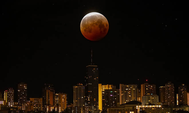 JAMM AQUINO / JAQUINO@STARADVERTISER.COM
                                In this multiple exposure made in the camera, the super flower blood moon turns red from a lunar eclipse early this morning over Honolulu.