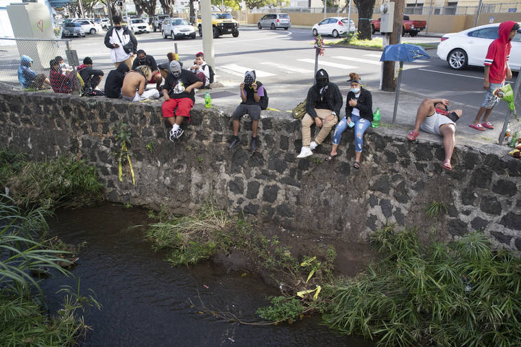 GEORGE F. LEE / APRIL 7
                                Mourners of 16-year-old Iremamber Sykap, who was shot by police, gathered at the corner of Kalakaua Avenue and Philip Street at the canal where Sykap was shot.