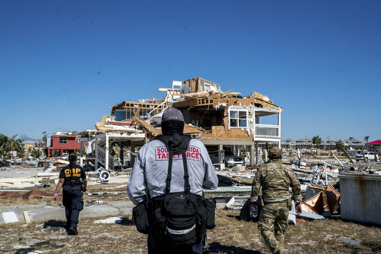 NEW YORK TIMES / 2018
                                A search and rescue team amid destroyed buildings following Hurricane Michael in Mexico Beach, Fla.