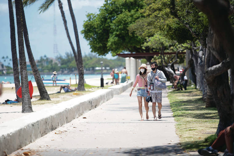 CINDY ELLEN RUSSELL / CRUSSELL@STARADVERTISER.COM
                                A couple wore masks to varying degrees Tuesday while walking near Ala Moana Regional Park.