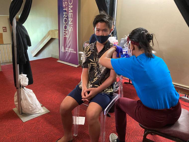 COURTESY QUEEN’S HEALTH SYSTEMS
                                Everett Pham, 12, receiving a COVID-19 Pfizer vaccine at Blaisdell Center today.